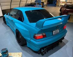 a blue car parked in a garage next to other cars