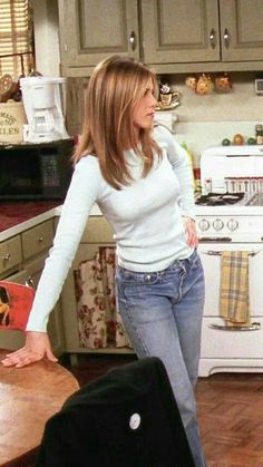 a woman standing in a kitchen next to an oven