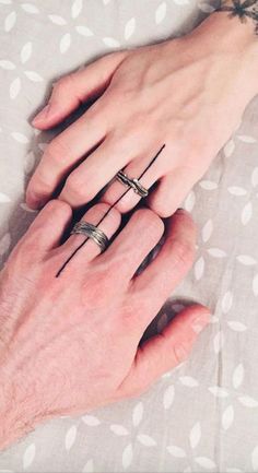 two hands holding each other with rings on their fingers