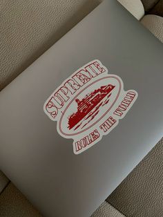 a laptop with the words supreme on it and a boat in the backround