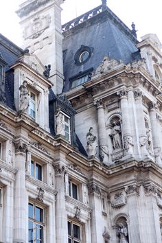 an old building with statues on the roof