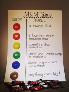 a sign that says m & m game share and five candy bars in front of it