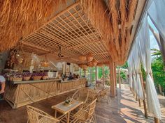 a restaurant with thatched roof and wicker chairs