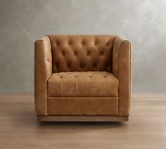 a brown chair sitting on top of a hard wood floor next to a gray wall