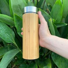 a person holding a bamboo bottle in their hand