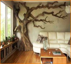 a living room with a tree painted on the wall