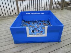 an empty blue plastic box sitting on top of a wooden deck