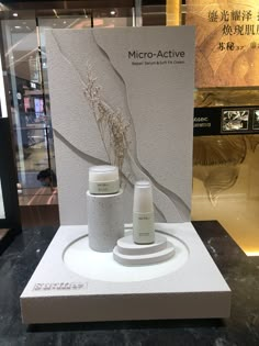 a display case with two vases on it in front of a sign that says micro - active