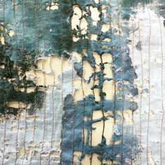 an old piece of fabric with blue and green paint peeling off the edges on it