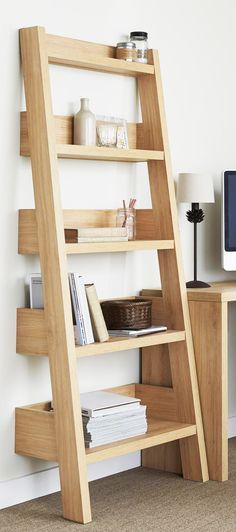 a wooden ladder leaning against a wall next to a desk with a computer on it