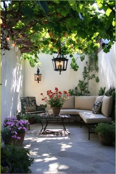 an outdoor seating area with potted plants and hanging lights