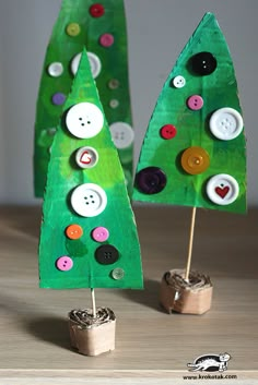 two paper christmas trees with buttons on them