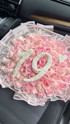 a bouquet of pink roses sitting in the center of a car seat with a number on it