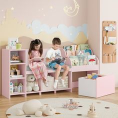 two children sitting on a pink bench in a playroom with toys and bookshelves