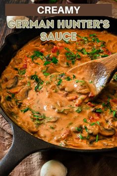 creamy german hunter's sauce in a skillet with a wooden spoon