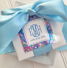 a gift wrapped in blue ribbon with the name emr on it and an envelope that says love, lilie kate