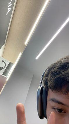 a young man wearing headphones is taking a selfie in front of a mirror