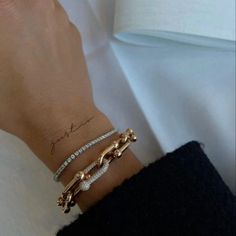 a close up of a person's wrist with two bracelets and a ring on it