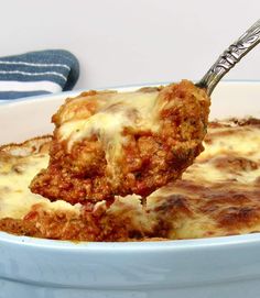 a close up of a spoon full of food with meatballs and cheese on it