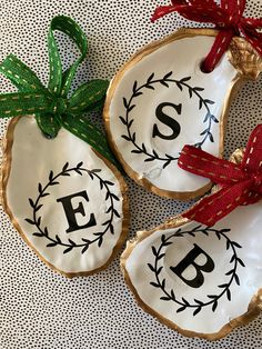 two decorated cookies with the letters f and p on them, tied to red bows