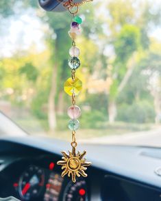 a car dashboard with a sun charm hanging from it's center console