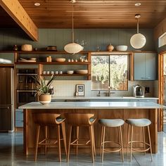 a kitchen with wooden cabinets and white counter tops, along with stools in front of the island