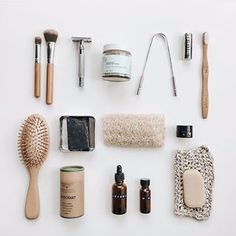 the contents of a personal care kit laid out on a white surface with brushes, soaps, and other items