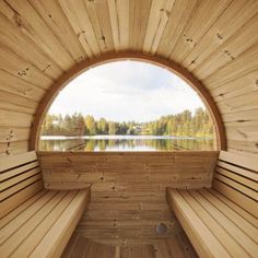 the inside of a wooden sauna with benches and a lake in the back ground