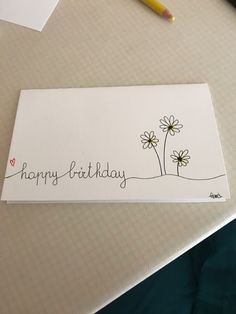 a happy birthday card sitting on top of a table next to a pen and paper