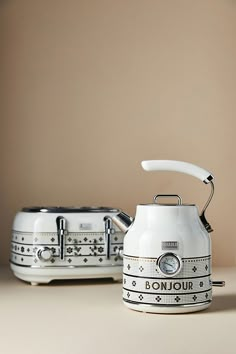 two tea kettles sitting next to each other on a table