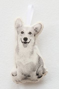 a white dog ornament hanging on a wall next to a piece of paper