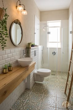 a bathroom with a toilet, sink and shower stall in the corner next to a ladder