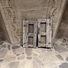 two wooden doors sitting on top of a stone floor