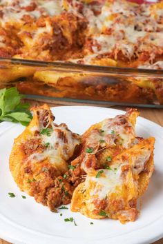 a white plate topped with lasagna shells next to a casserole dish