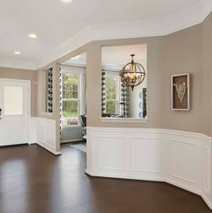 an empty living room with hard wood floors and white wainscoting on the walls