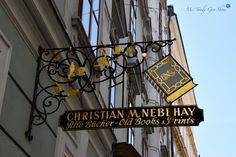 the sign for christian m nebi hay and other old books & prints hangs from the side of a building