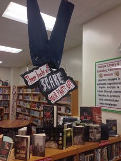 there is a book store with books on the shelves and hanging upside down signs above them