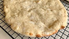 an uncooked pizza sitting on top of a cooling rack next to two slices of bread