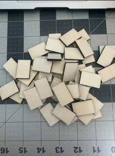 several pieces of wood cut into squares on top of a cutting board with rulers next to them