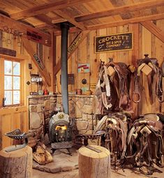 a room filled with lots of different types of saddles hanging on the wall next to a fire place