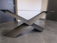 a modern glass and metal table in an empty room