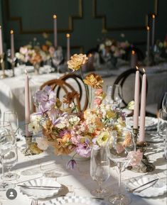 the table is set with flowers and candles