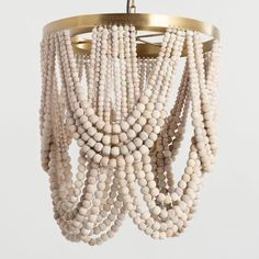 a white chandelier with wooden beads hanging from it's centerpieces