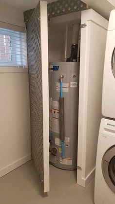 a white washer and dryer in a room with a door open to reveal a water heater