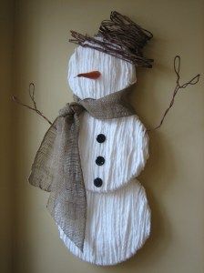 a snowman made out of yarn is hanging on the wall