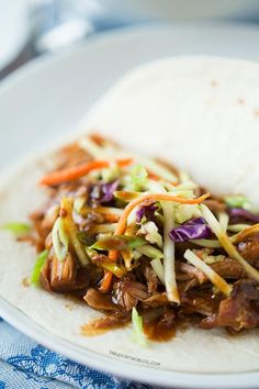 a white plate topped with meat and veggies on top of a bed of rice