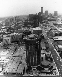 an aerial view of the city with tall buildings and parking lot in the foreground