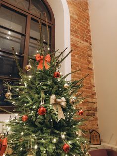 a decorated christmas tree in front of a window