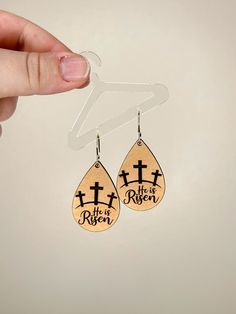 a pair of wooden earrings with the words, life is better on it and a cross