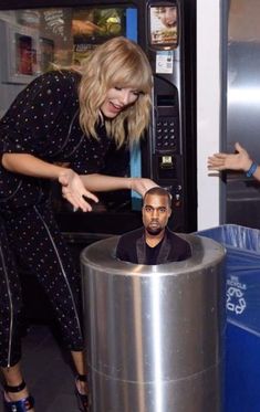 a woman standing next to a metal trash can